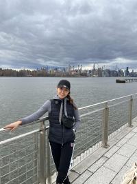 Woman standing by a guardrail over a river by New York City