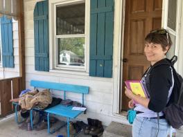 A woman standing next to a door and window