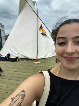 a photo of Hall in front of a tipi at the 2023 North American Indigenous Games on the Halifax Waterfront.
