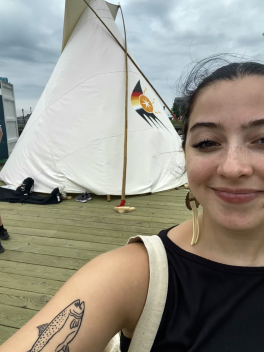 Hall in front of a tipi at the 2023 North American Indigenous Games on the Halifax Waterfront.