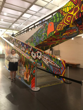 Mello at MASP standing beside the work made by Indigenous artist collective MAHKU at the Museu de Arte de Sao Paulo