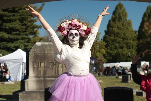A woman dressed like a skeleton with a flower headband