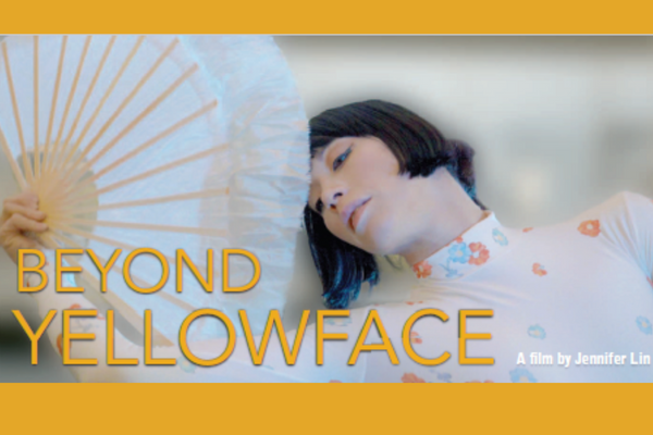 An Asian woman behind a big paper fan
