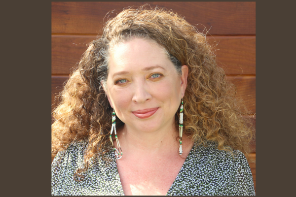 Woman with long light brown hair and blue eyes smiling
