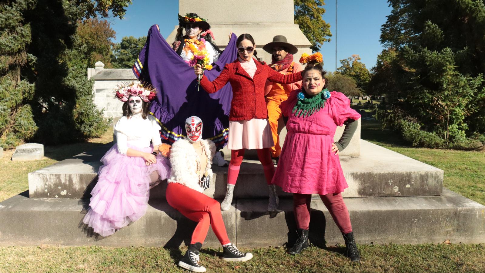 Group of performers next to a large monument