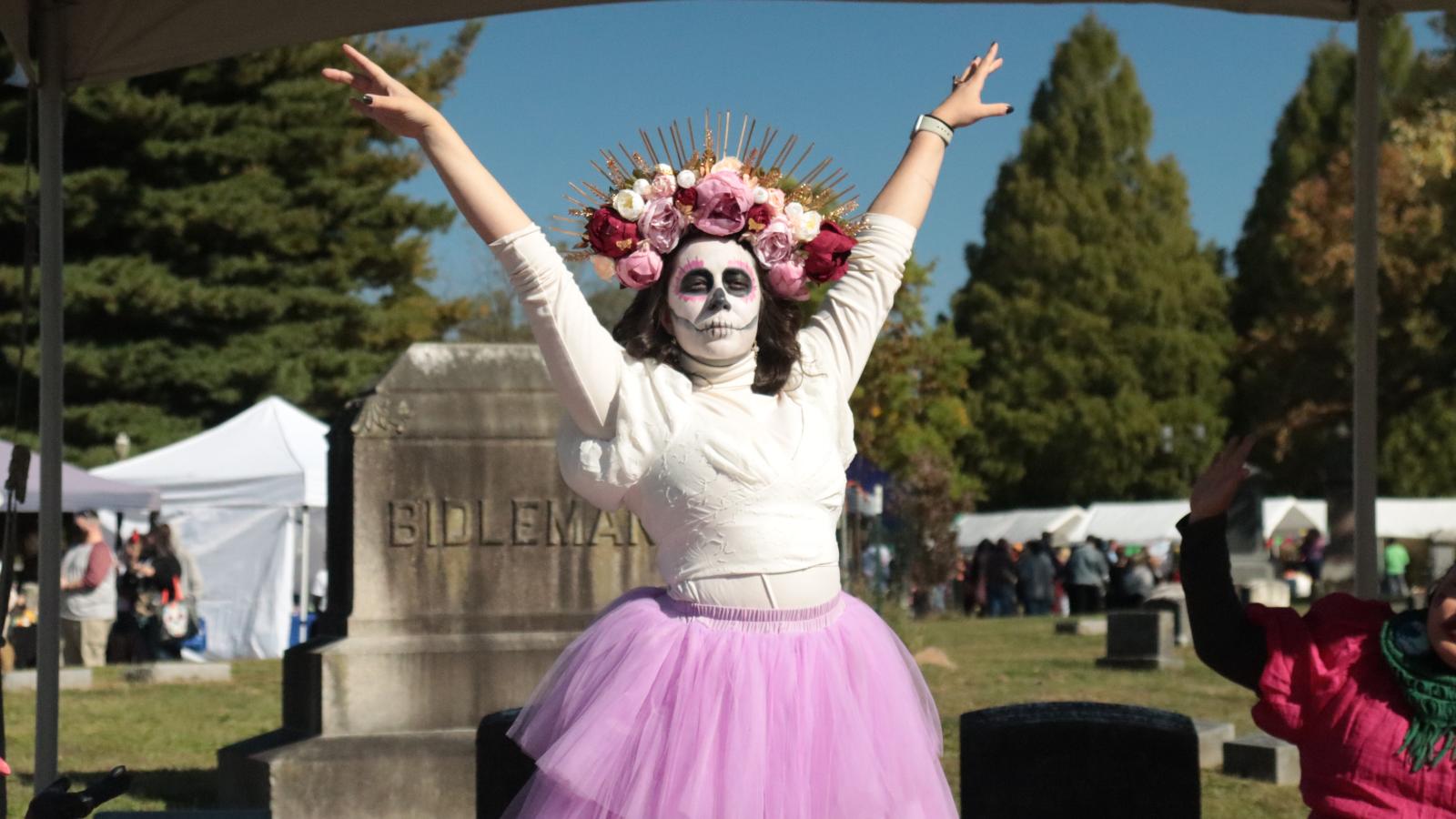 A woman dressed like a skeleton with a flower headband