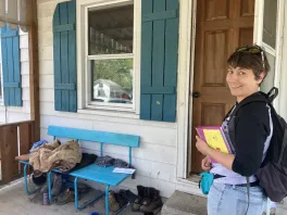 A woman standing next to a door and window